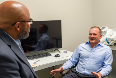 Doctor sitting in a chair talking to another man
