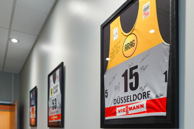 a basketball jersey hanging on a wall in a hallway